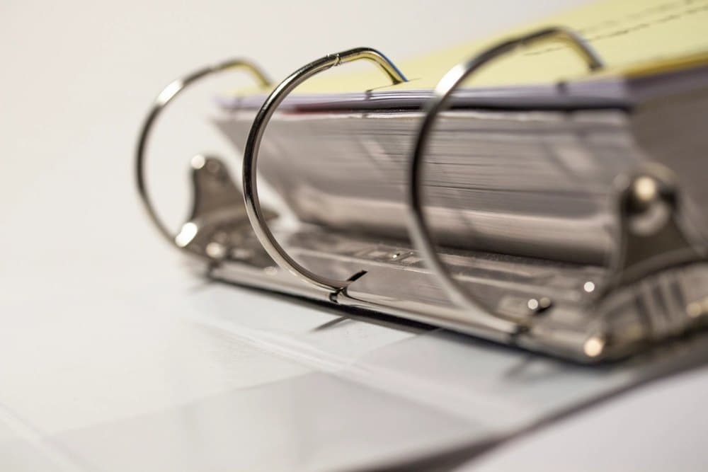 An open ring binder holding a tabbed set of documents, the kind used for a trial notebook.